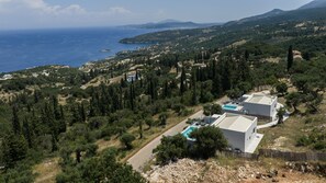 A coastal property with a swimming pool, surrounded by dense greenery and a view of the sea. - Askos Zelia II Luxury Suite, a Zakynthian Hideaway (VPV2+JPG Elation)