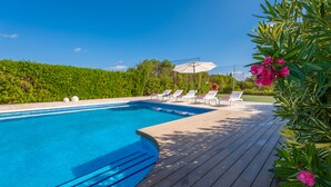 A swimming pool with a wooden deck, lounge chairs, and a clear blue sky. - L'ERESTA - Wonderful villa with private pool and Free Wifi (Pollença)