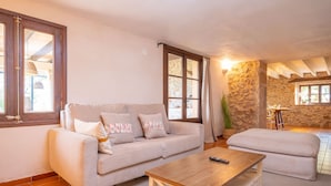 A cozy living room with a sofa, ottoman, and wooden coffee table. - L'ERESTA - Wonderful villa with private pool and Free Wifi (Pollença)