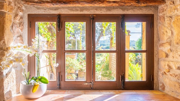 A stone wall with a wooden door and a window with multiple panes. - L'ERESTA - Wonderful villa with private pool and Free Wifi (Pollença)