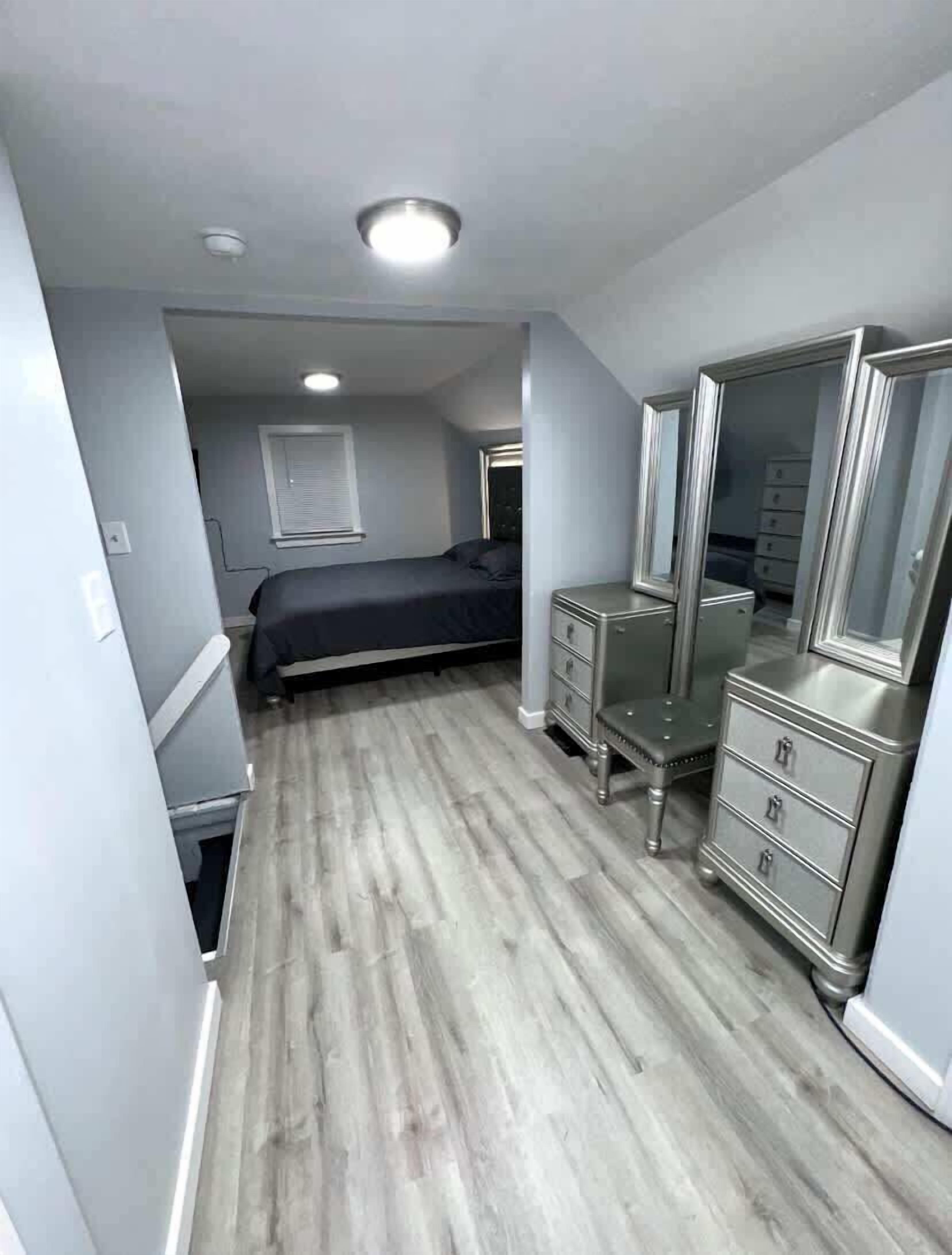 Une chambre à coucher avec un lit, une commode et un miroir.