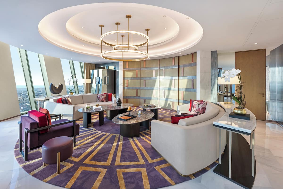 Un salon moderne avec un canapé, une table basse et une grande fenêtre donnant sur la ville.