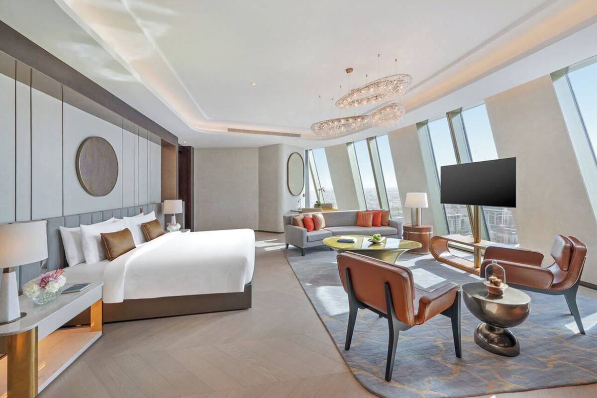 Une chambre d’hôtel moderne dotée d’un grand lit, d’un canapé, d’un coin repas et d’une télévision.
