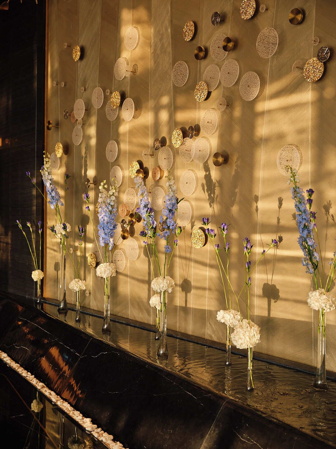 Una pared decorada con adornos circulares y jarrones con flores.