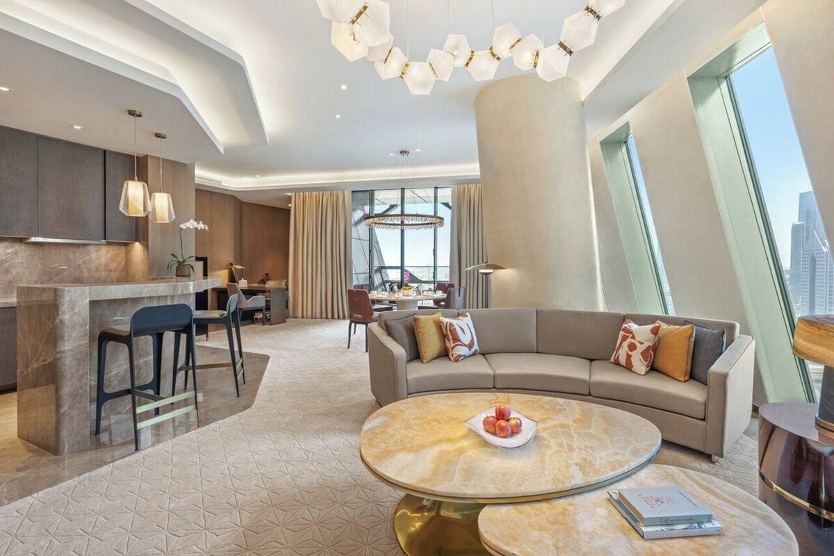 Un hall d’hôtel moderne avec un canapé incurvé, une table basse ronde et un coin repas.