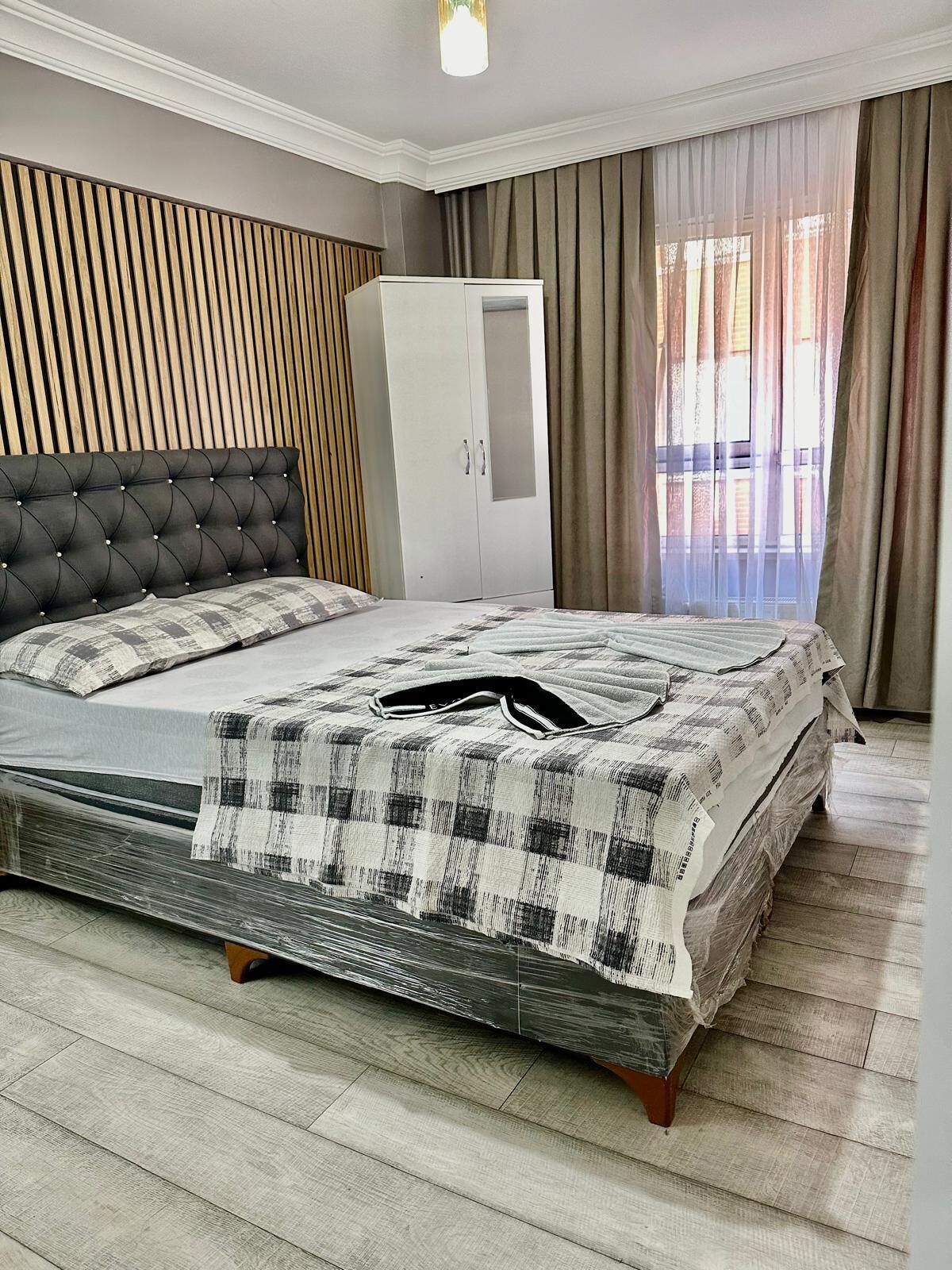 Une chambre à coucher avec un lit, une armoire et une fenêtre avec des rideaux.