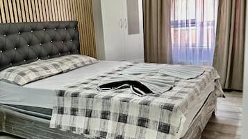 Une chambre à coucher avec un lit, une armoire et une fenêtre avec des rideaux.