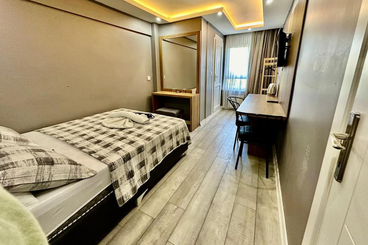 Une chambre d’hôtel avec deux lits, un bureau et une chaise.