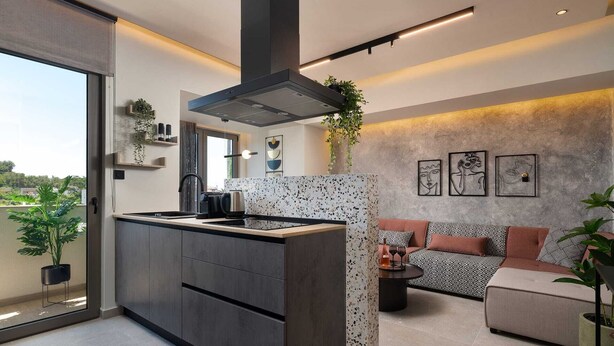 A modern kitchen with a central island, a built-in stove, and a large window.