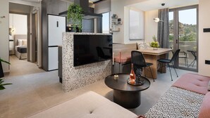 A modern kitchen with a built-in stove, a dining area with a table and chairs, and a balcony with a view.