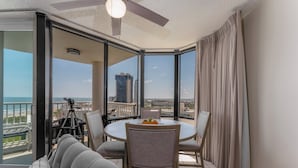 A balcony with a dining table and chairs, a sofa, and a tripod.