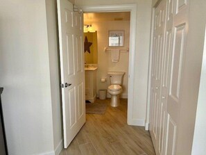 A narrow hallway leading to a bathroom with a toilet, sink, and a star decoration on the wall. - Towers 8 & 9 8301 - Daytona Beach Oceanfront Vacations, Inc (Ponce Inlet)