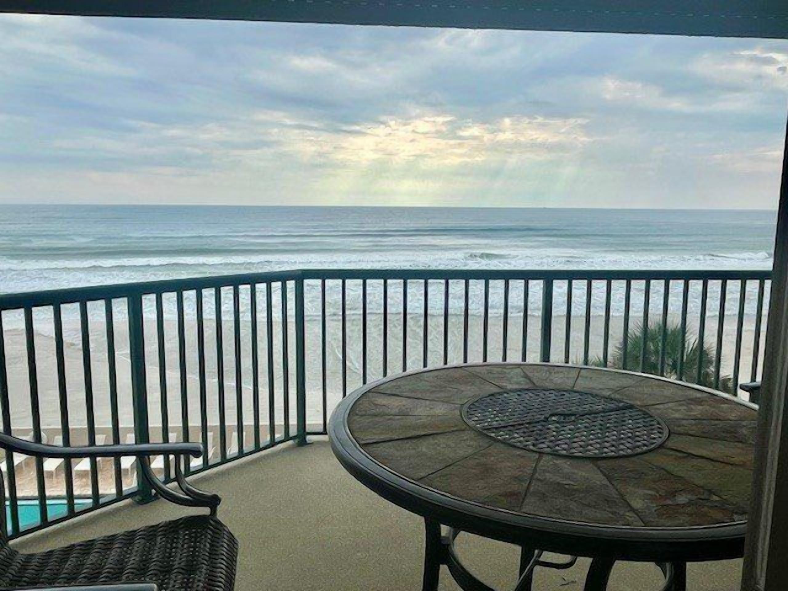 Ein Balkon mit Blick auf das Meer und den Strand.