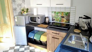 A compact kitchen with a refrigerator, microwave, coffee maker, and a sink. - Urlaub in Masuren - Ferienhaus, Angelurlaub (Iława)