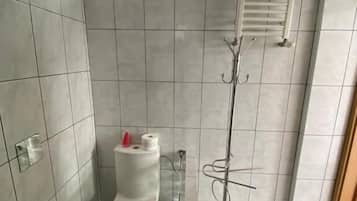 Un baño moderno con inodoro, bidé y ducha con puerta de cristal.
