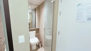 A narrow bathroom with a toilet, a small trash bin, and a glass shower enclosure. - Setai Yacht S4- By Almare Flats (João Pessoa)