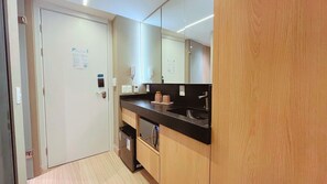 A modern bathroom with a white door, a black countertop, a mirror, and a sink. - Setai Yacht S4- By Almare Flats (João Pessoa)