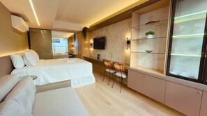 A modern hotel room with a large bed, a desk with two chairs, a TV mounted on the wall, and a large window with a view.