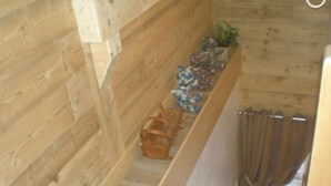 Een houten interieur met een ingebouwde bank en een kleine plant aan de muur.