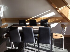A modern dining area with a high ceiling and skylight, featuring a table and chairs. - 50m from shops, 1st floor, parking, tv, ski locker, 60m², Valloire (Valloire)