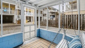Un patio couvert avec une balançoire et une vue sur le jardin.