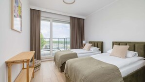 Ein Hotelzimmer mit zwei Betten, einem Holztisch und Blick ins Freie.