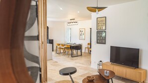 A modern living room with a TV, wooden furniture, and artwork on the walls. - 10 minutes from the prestigious Av de Champagne in EPERNAY, Maison à la Campagne. (Athis)