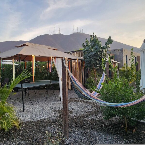 A hammock between two structures with a view of mountains in the background. - HOP Terracota in Cerro Prieto (Salas)