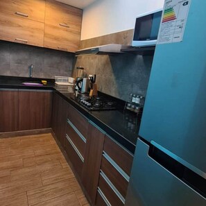Enjoy cooking in this fully equipped kitchen with a gas stove, sink, and refrigerator.