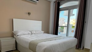 Ein Schlafzimmer mit einem Bett, einem Nachttisch und einem Fenster mit Vorhängen.