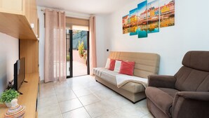 Una sala de estar moderna con un sofá, un sillón marrón, un televisor de pantalla plana y una planta en maceta.
