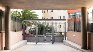 Una entrada cerrada con portones metálicos y suelo de hormigón.