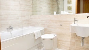 A modern bathroom with a bathtub, toilet, and sink. - Great George Lane Sum (Glasgow City)