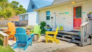 A house with a red door, a blue roof, and colorful decorations on the walls. - Panama City Home w/ Fire Pit - Walk to Beaches! (Panama City Beach)