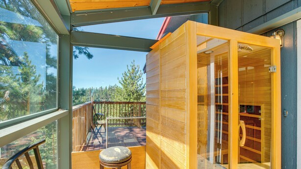 A wooden cabin with a glass door leading to a deck, a wooden bench, and a view of trees. - Scenic Home w/ Sauna - 7 Mi to Heavenly Mountain! (Stateline)