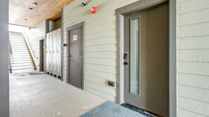Un couloir avec des casiers, une porte et un plafond en bois.