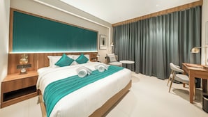 Ein modernes Hotelzimmer mit einem großen Bett, einem Schreibtisch und einem Sessel.