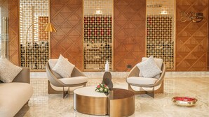 Eine Lobby mit zwei Sofas, einem Couchtisch und dekorativen Wandverkleidungen.