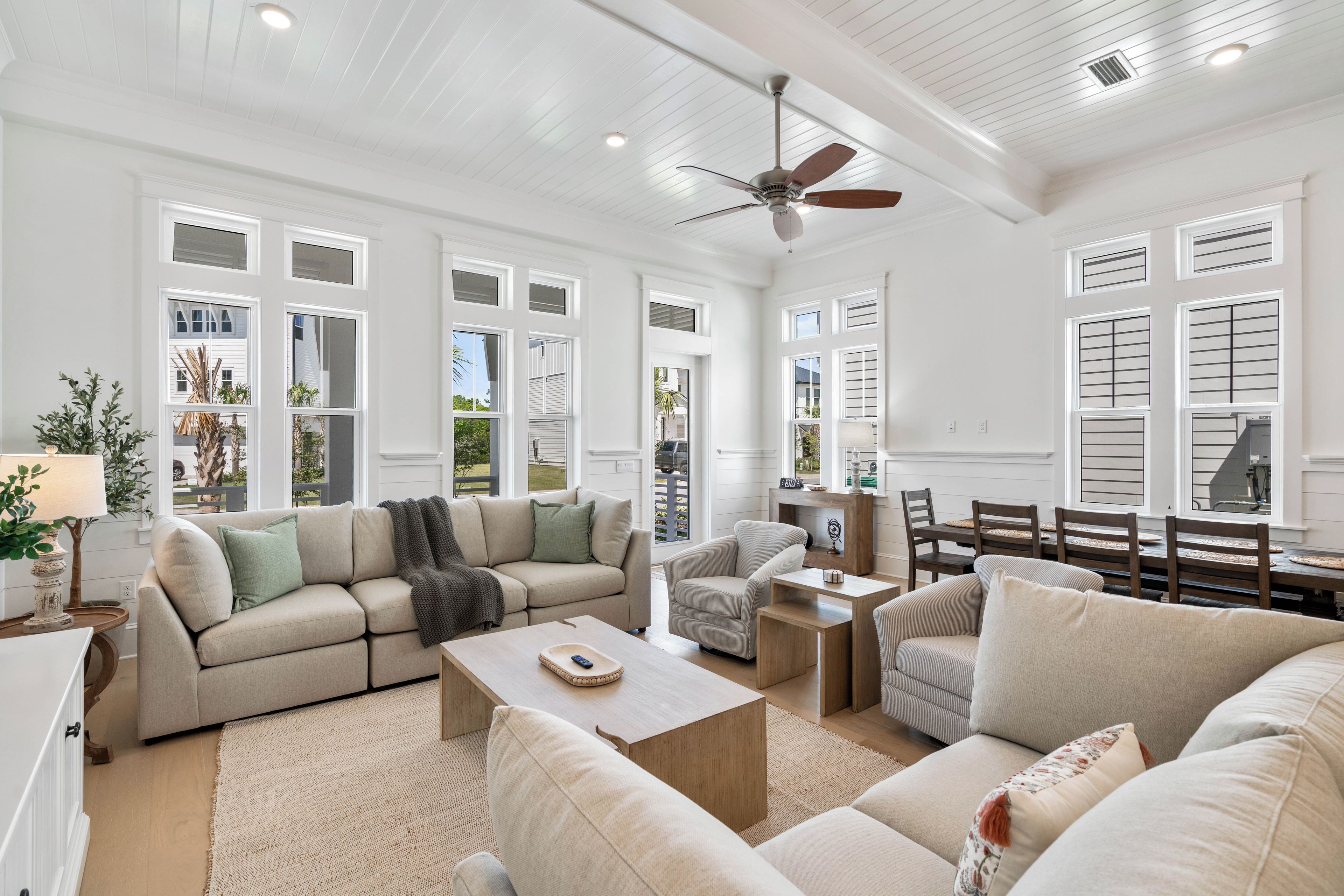 A spacious living room with a large sofa, a coffee table, and a dining area with a table and chairs.