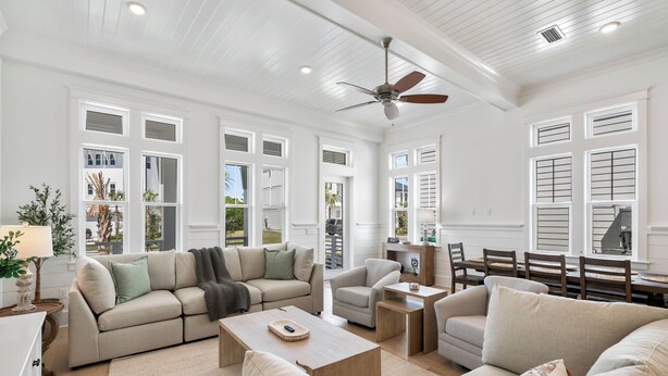 A spacious living room with a large sofa, a coffee table, and a dining area with a table and chairs.