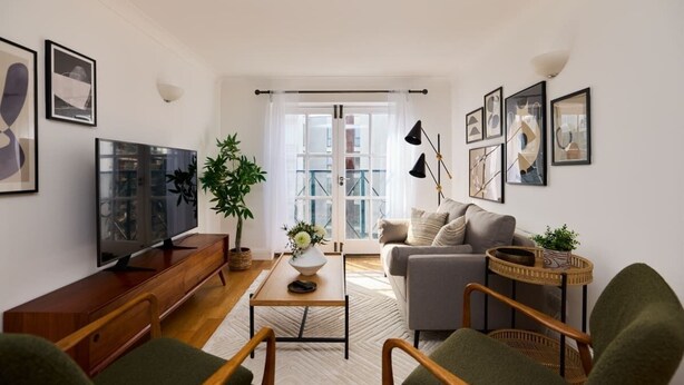 A modern living room with a TV, sofa, coffee table, and chairs.