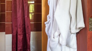 A bathroom with a wooden door, a white towel rack, and a red shower curtain. - Poolside 2-Bedroom Apartment with heated pool at the Jungle Oasis (Nairobi)