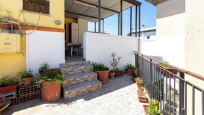 A residential building with a staircase leading to an upper floor, surrounded by potted plants and a metal railing. - 4088 Da Nonno Claudio by Barbarhouse (Galatina)