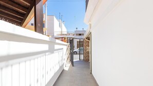 A narrow, sunlit corridor with a white railing, leading to a gated entrance. - 4088 Da Nonno Claudio by Barbarhouse (Galatina)
