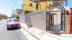 A red car parked on a street next to a building with a stone facade and a glass entrance. - 4088 Da Nonno Claudio by Barbarhouse (Galatina)