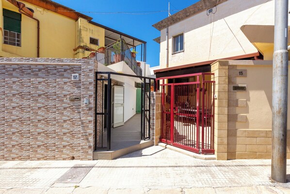 A residential building with a gated entrance, a visible staircase, and a number '15' on the wall. - 4088 Da Nonno Claudio by Barbarhouse (Galatina)