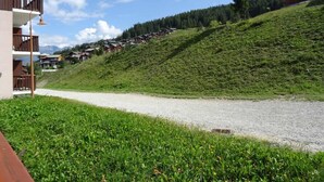 Una ladera con un camino de grava que conduce a una hilera de casas de madera.