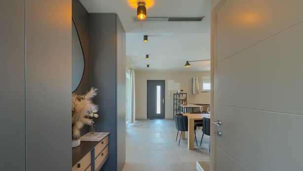 A modern hallway with a wooden dining table and chairs, a vase with dried plants, and a door leading to a bright room. - Villa Loreta with pool, barbeque and sea view. (Pula)