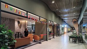Un espace intérieur moderne comprenant un espace d’accueil, des sièges et un plafond au design original.