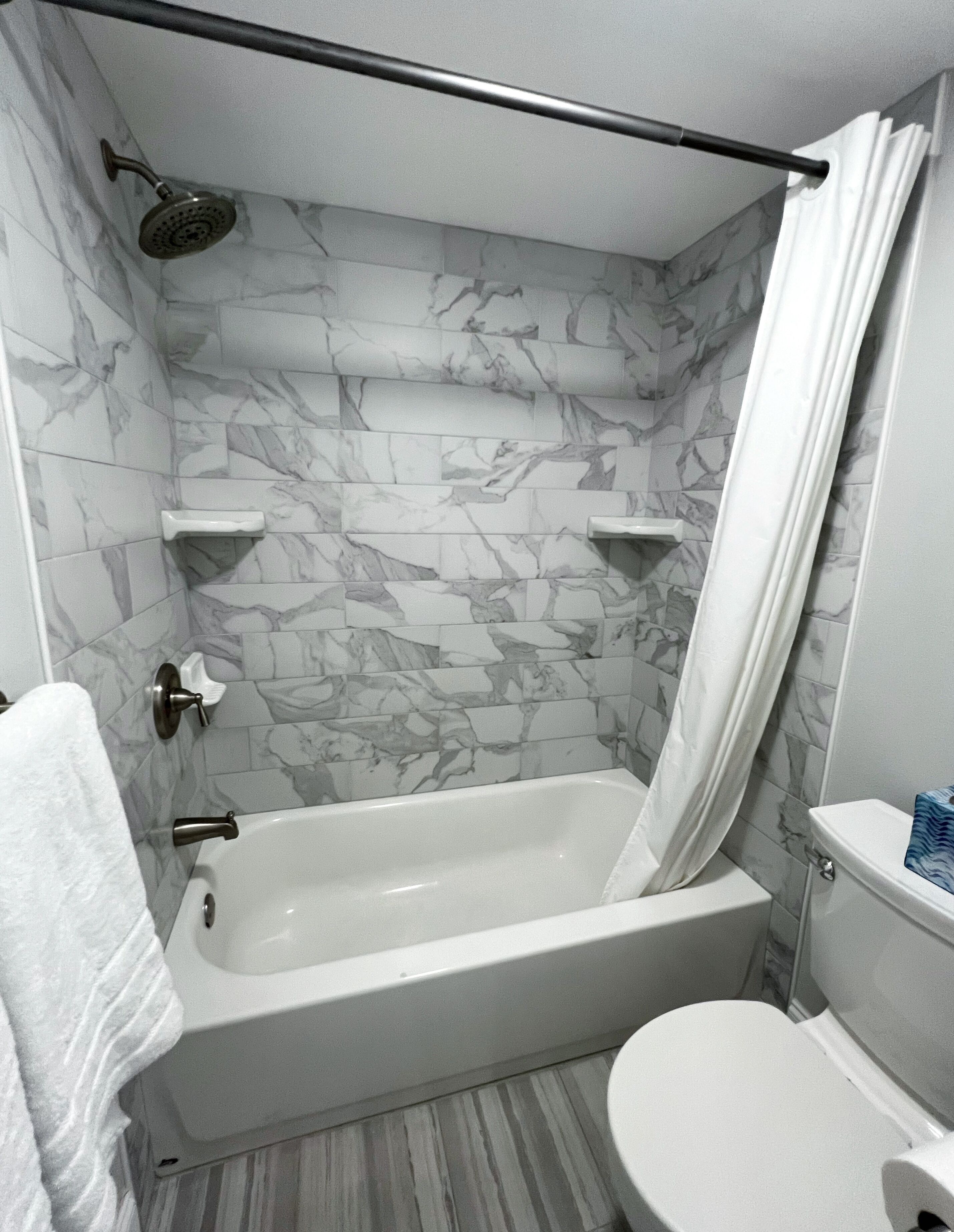 Une salle de bain avec une baignoire, des toilettes et une douche.